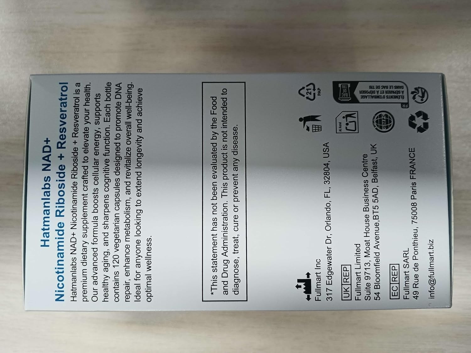 Supplement label with text and icons on a wooden surface